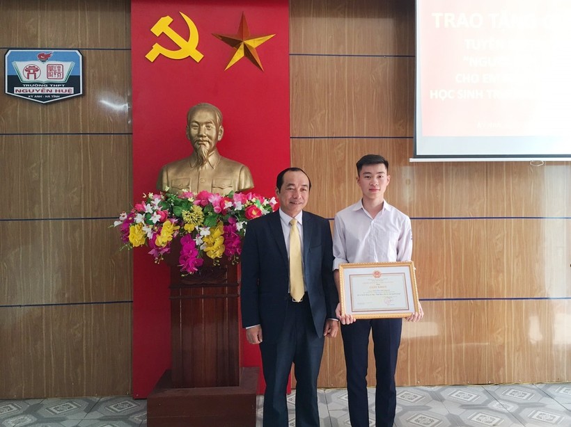 Ông Trần Trung Dũng, Giám đốc Sở Giáo dục và Đào tạo tặng Giấy khen cho em Nguyễn Việt Thạch.