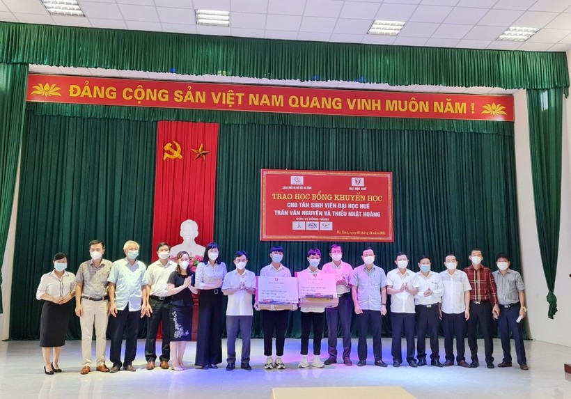 Lãnh đạo tỉnh Hà Tĩnh, lãnh đạo Trường Đại học Huế trao những suất quà cho 2 em Nguyên và Hoàng tại buổi lễ.