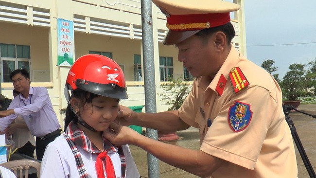 Đại diện Cảnh sát giao thông tỉnh Bạc Liêu tặng mũ bảo hiểm cho học sinh.
