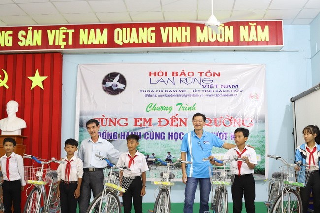 Đại diện lãnh đạo Hội Bảo tồn lan rừng Việt Nam và chính quyền địa phương trao tặng xe cho học sinh.