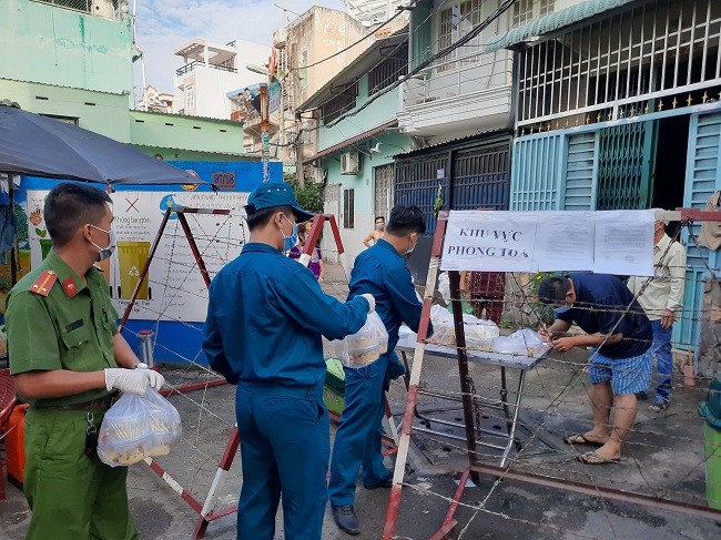 Lực lượng chức năng  hỗ trợ cung cấp đồ ăn, thức uống cho cư dân ở khu phố 4 đường Phạm Phú Thứ Quận 6 đang bị phong tỏa.

