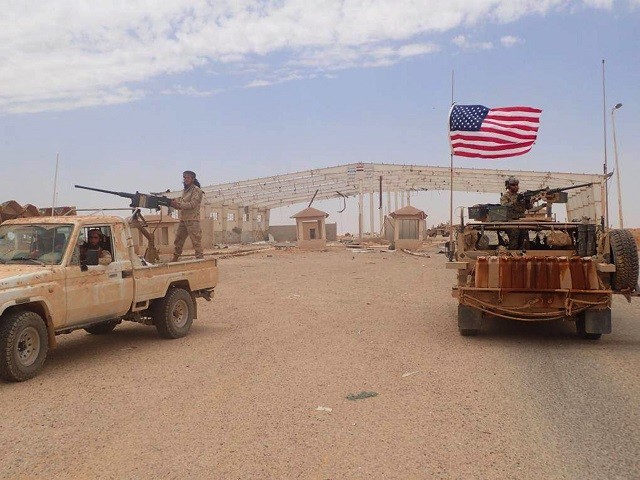 Binh lính chống chính phủ Maghaweer al-Thawra do Mỹ ủng hộ đang đứng trên xe có nhiều súng máy tự động (trái), bên phải là một lính Mỹ cũng đứng trên xe bọc thép tại Tanf, biên giới Syria - Iraq
