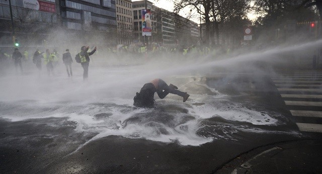 Một người biểu tình bị vòi phun nước bắn vào tại Brussels, Bỉ.