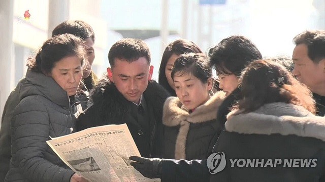 Một nhóm người đọc báo Triều Tiên đăng tin về chuyến đi của Chủ tịch Kim Jong-un tới Việt Nam dự thượng đỉnh