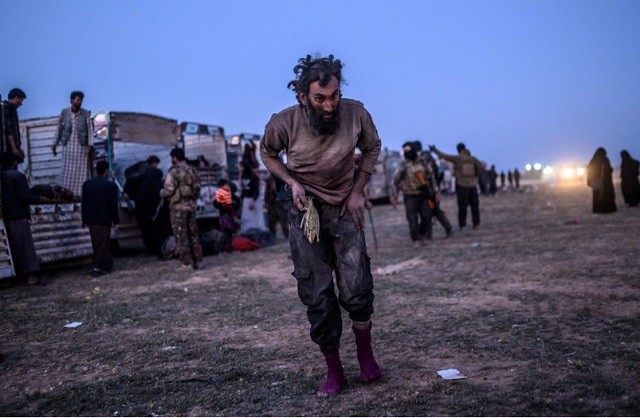 Một người đàn ông nghi là phần tử IS đi qua các thành viên của lực lược SDF