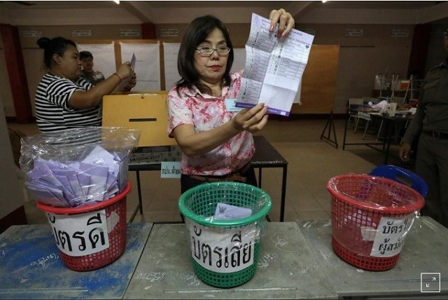 Một nhân viên của Ủy ban Bầu cử Thái Lan đang cầm một lá phiếu