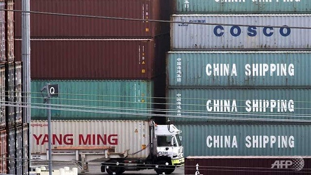 Một chiếc xe tải đi qua containers hàng Trung Quốc tại cảng Los Angeles (Mỹ). Ảnh: AFP.