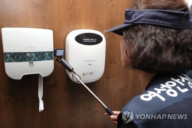 Một nhân viên an ninh kiểm tra khả năng camera giấu trong phòng vệ sinh của một trường học ở Seoul.