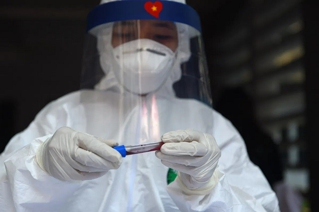 Một nhân viên y tế lấy máu xét nghiệm Covid-19 ở Hà Nội.