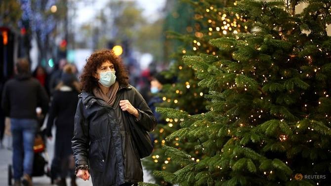Người dân đeo khẩu trang đi qua cây thông Noel ở Anh.