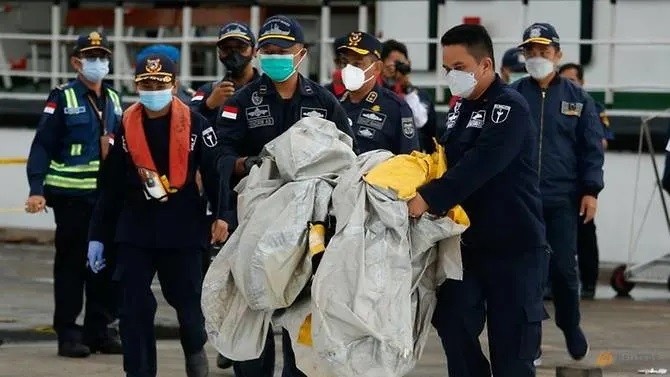Các thành viên cứu hộ Indonesia mang theo những gì được cho là mảnh vỡ của máy bay Sriwijaya Air chuyến bay SJ182 tại cảng Container Quốc tế Jakarta ở Jakarta, Indonesia, ngày 10 tháng 1 năm 2021. (Ảnh: REUTERS/Ajeng Dinar Ulfiana).
