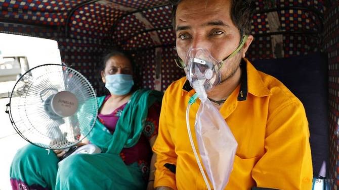 Một bệnh nhân đeo máy thở chờ đợi để được nhập viện ở Ấn Độ.