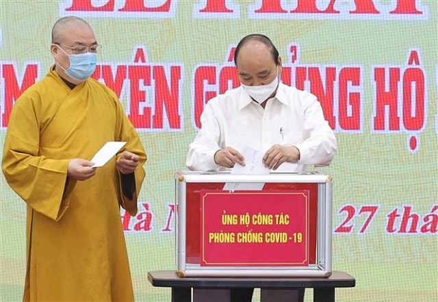 Chủ tịch nước Nguyễn Xuân Phúc quyên góp ủng hộ phòng, chống dịch COVID- 19. Ảnh: Thống Nhất/TTXVN.
