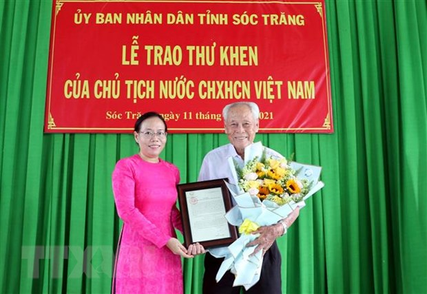 Phó Chủ tịch UBND tỉnh Sóc Trăng Huỳnh Thị Diễm Ngọc trao thư khen của Chủ tịch nước cho ông Trần Cang. Ảnh: TTXVN.

