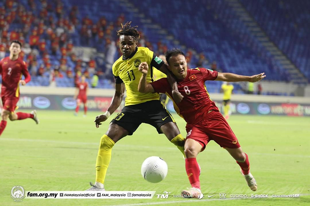 Mohamadou Sumareh của Malaysia cố gắng lừa bóng qua Nguyễn Trọng Hoàng trong trận đấu với Việt Nam trên sân vận động Al-Maktoum. 