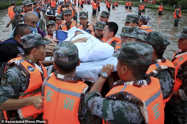 Quân nhân Trung Quốc sơ tán người dân khỏi bệnh viện nơi có khoảng 3.000 người bị mắc kẹt do lũ lụt ở Trịnh Châu, tỉnh Hà Nam, miền trung Trung Quốc.