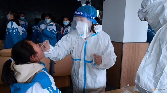 Nhân viên y tế Trung Quốc lấy mẫu xét nghiệm Covid-19 tại một trường học.