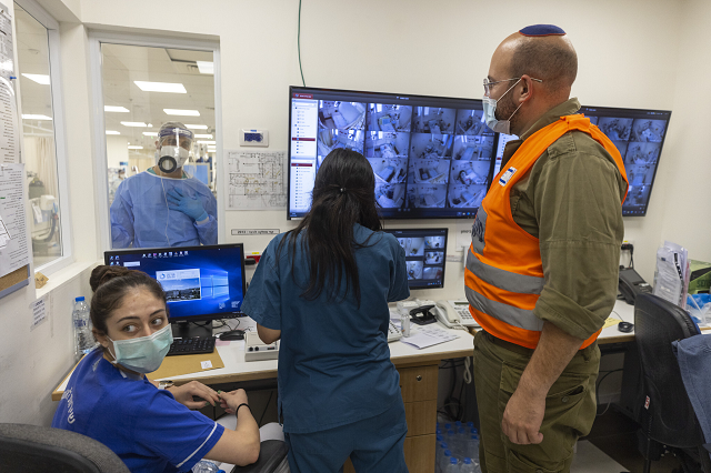 Nhân viên y tế và một binh sĩ Israel trong phòng giám sát của khu điều trị Covid-19 tại một bệnh viện ở Jerusalem.