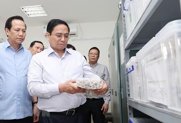 Thủ tướng Phạm Minh Chính xem quy trình bảo quản mẫu hài cốt liệt sỹ. (Ảnh: Dương Giang/TTXVN) 