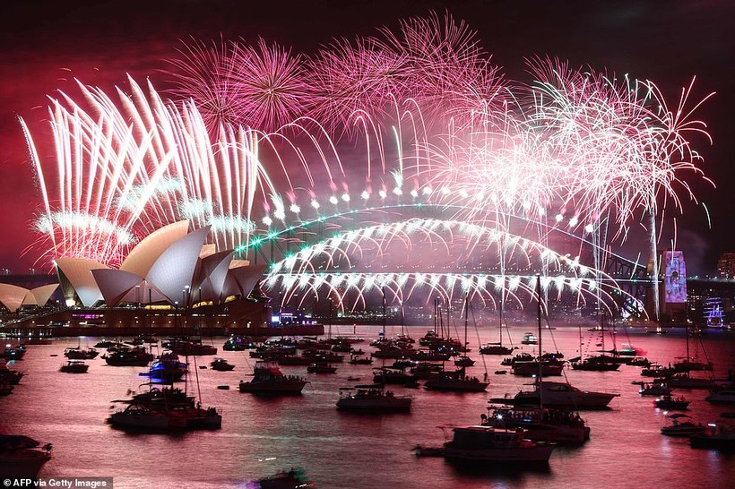Pháo hoa đêm giao thừa thắp sáng bầu trời Nhà hát Opera Sydney (trái) và Cầu Cảng trong màn bắn pháo hoa ở Sydney vào ngày 1/1/2023