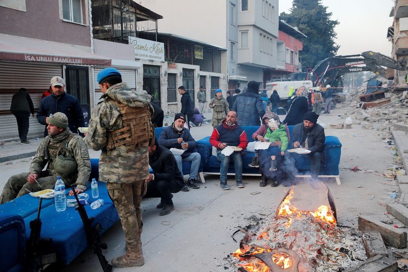 Binh lính Thổ Nhĩ Kỳ trò chuyện với người dân địa phương khi họ ăn trưa, sau hậu quả của trận động đất chết người, ở Hatay.