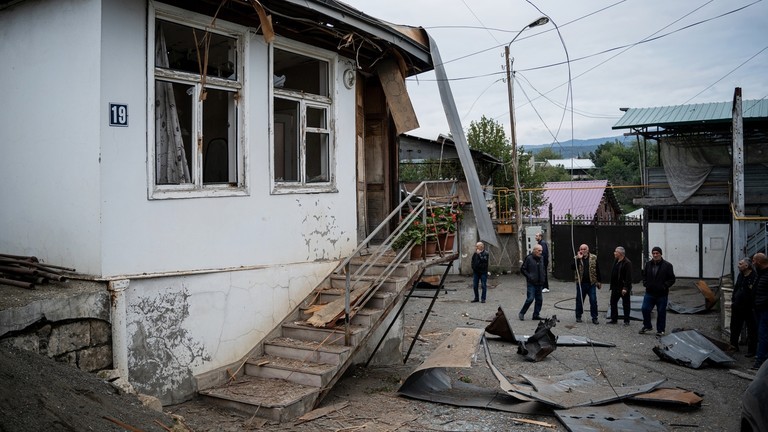 Người dân tụ tập gần một tòa nhà dân cư bị hư hại do pháo kích ở Stepanakert, thủ phủ của vùng ly khai Nagorno-Karabakh. (Ảnh: Sputnik)