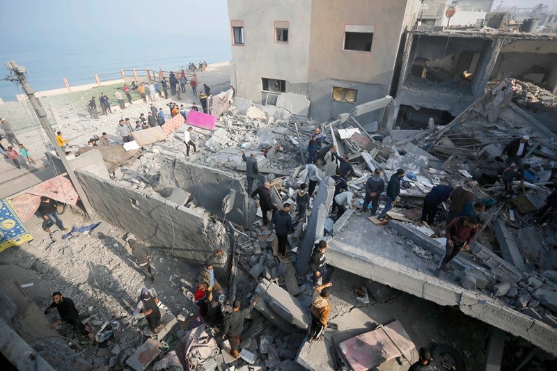 Các đội cứu hộ Palestine và dân thường tìm kiếm người sống sót trong đống đổ nát các tòa nhà bị Israel không kích ở Deir el-Balah. (Ảnh: Ashraf Amra/Anadolu)
