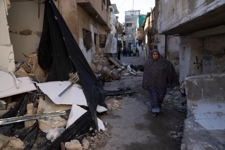 Một người tị nạn Palestine đi ngang qua những ngôi nhà bị phá hủy trong trại tị nạn Tulkarem ở Bờ Tây sau cuộc đột kích của Israel. (Ảnh: AP)