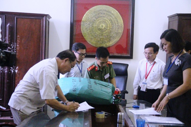 Ông Mai Văn Trinh (người thứ 2 bên phải qua) Cục trưởng Cục Quản lý chất lượng, Bộ GD&ĐT chứng kiến việc giao nhận đề thi tại một điểm thi ở Thanh Hóa.