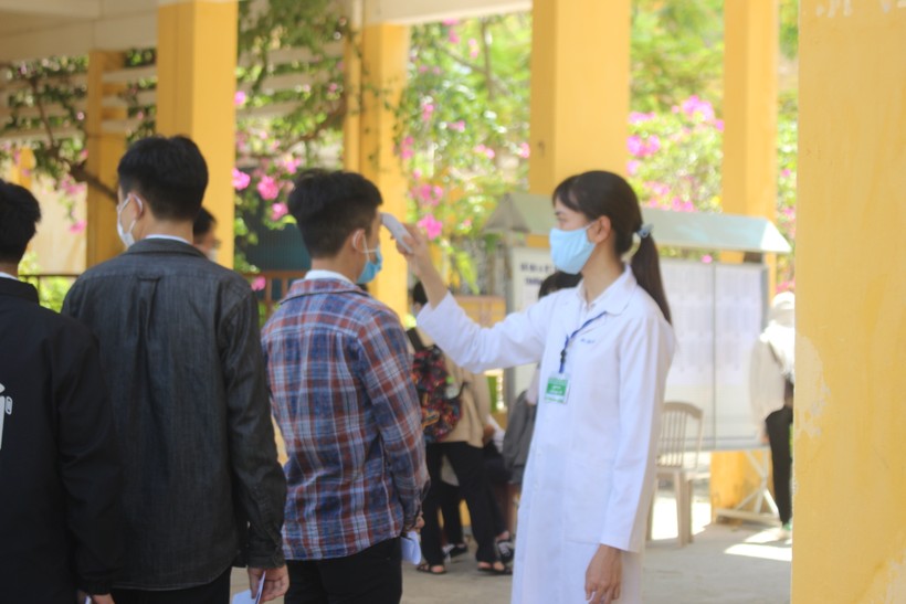 Thí sinh dự thi tốt nghiệp THPT lần 1 ở Quảng Nam được đo thân nhiệt trước khi vào cổng trường thi.
