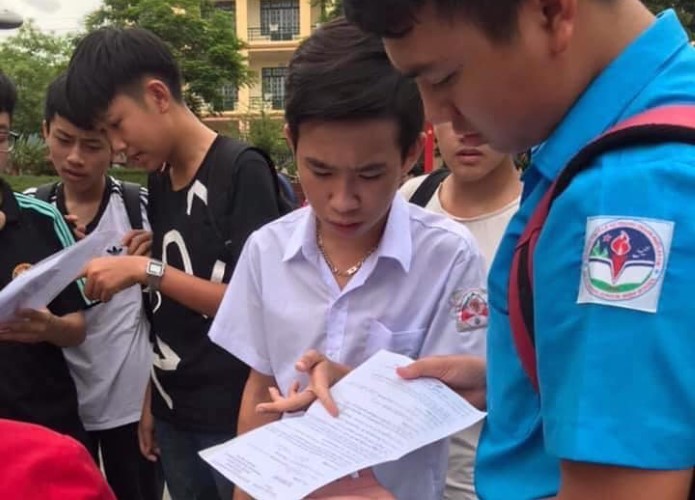 Phạm Vương Minh Quang (áo trắng) trao đổi cùng bạn sau kỳ thi tuyển sinh vào lớp 10. Ảnh: NTCC
