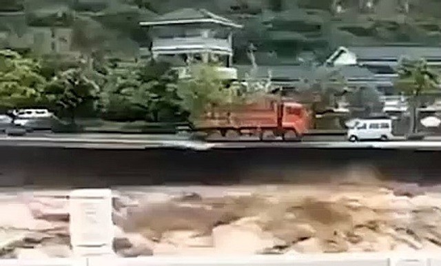 Chiếc xe tải đỏ trước khi rơi xuống dòng lũ dữ