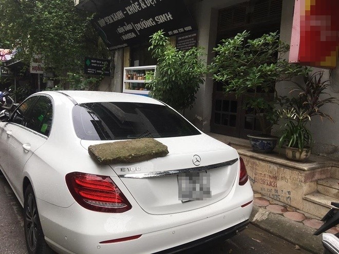 Hình ảnh cục bê tông xù xì được đặt chễm chệ lên cốp sau xe Mercedes-Benz như một lời “cảnh cáo” gửi tới chủ xe. Ảnh: Báo dân sinh