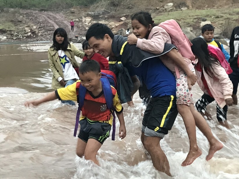 Thầy Nguyễn Trung Hiếu cùng học sinh lội sông đến trường. Ảnh: NVCC.