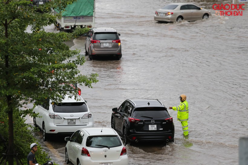CSGT chân trần ngâm nước mưa hàng giờ để  phân luồng giao thông tại điểm ngập úng
