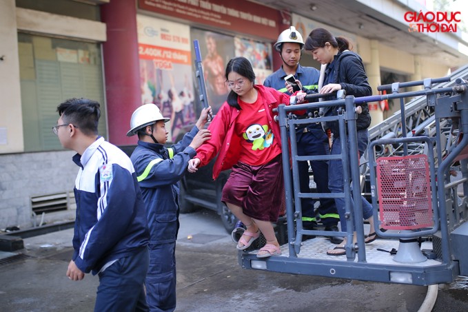Lực lượng PCCC đưa người dân ở tầng cao xuống bằng xe thang.