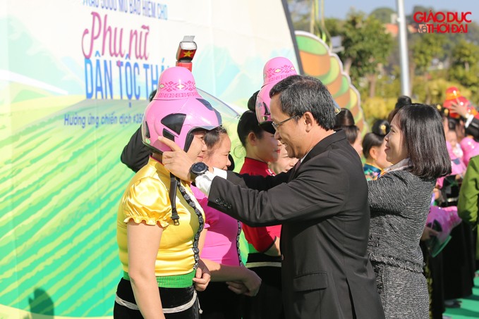 Ông Khuất Việt Hùng trao những chiếc mũ bảo hiểm" độc" cho phụ nữ dân tộc Thái.