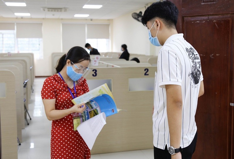 Kiểm tra hồ sơ thí sinh vào phòng thi ở kỳ thi đánh giá năng lực của Đại học Quốc gia Hà Nội.