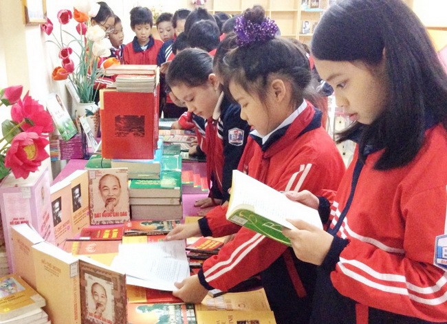 Học sinh trường Tiểu học Giang Biên đọc sách bên Tủ sách Bác Hồ