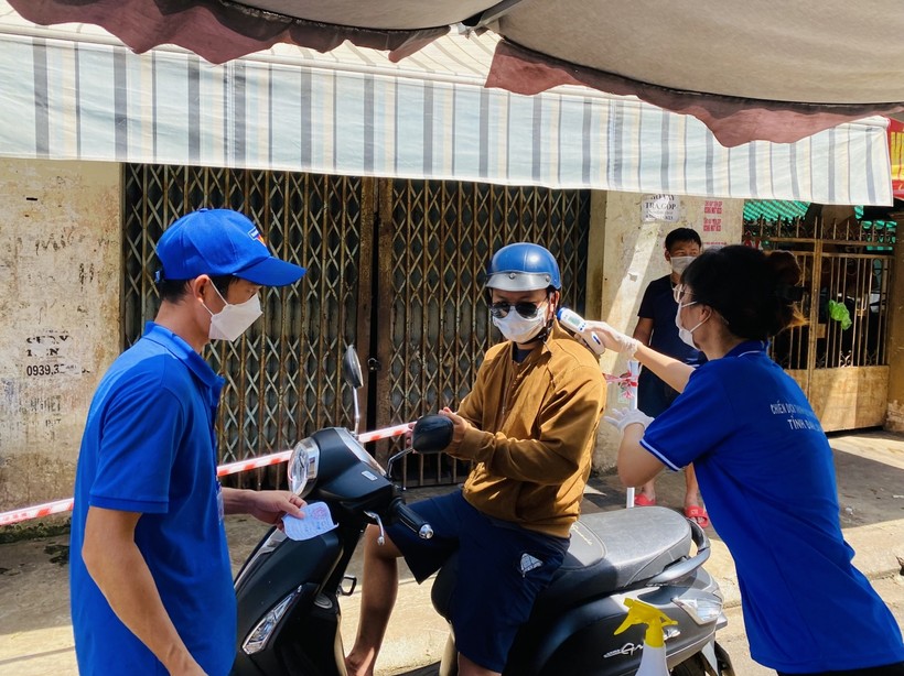 Lực lượng chức năng kiểm tra giấy tờ của người dân khi vào mua hàng tại chợ Phan Chu Trinh, phường Tân Lợi, TP Buôn Ma Thuột.