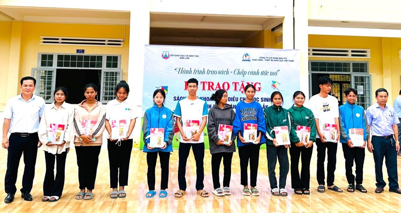 Ban tổ chức tặng tập vở, sách giáo khoa cho học sinh Trường THPT Nguyễn Chí Thanh - Ảnh: TT.