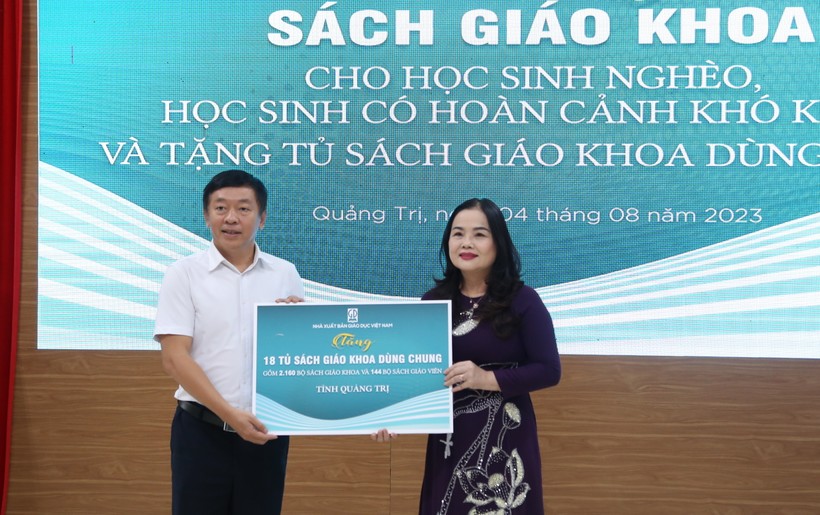 TS Lê Thị Hương, Giám đốc Sở GD&ĐT Quảng Trị tiếp nhận tượng trưng sách giáo khoa do ông Thừa Phú - Giám đốc NXBGD Việt Nam tại Đà Nẵng trao tặng.
