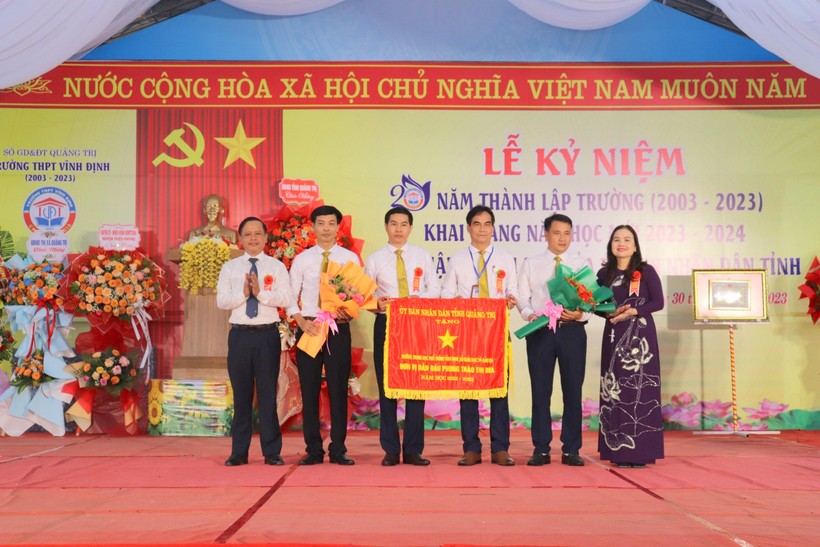 TS Lê Thị Hương, Giám đốc Sở GD&ĐT Quảng Trị trao Cờ thi đua của UBND tỉnh cho Trường THPT Vĩnh Định.
