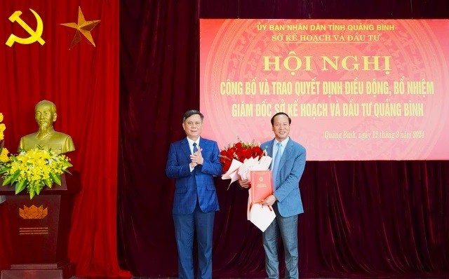 Ông Trần Thắng, Chủ tịch UBND tỉnh Quảng Bình trao quyết định và tặng hoa chúc mừng Giám đốc Sở Kế hoạch và Đầu tư Nguyễn Xuân Đạt.