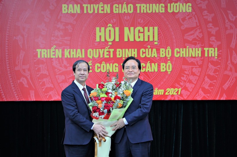 Bộ trưởng Bộ Giáo dục và Đào tạo Nguyễn Kim Sơn (bên trái) tặng hoa tân Phó Trưởng Ban Tuyên giáo Trung ương Phùng Xuân Nhạ (bên phải).