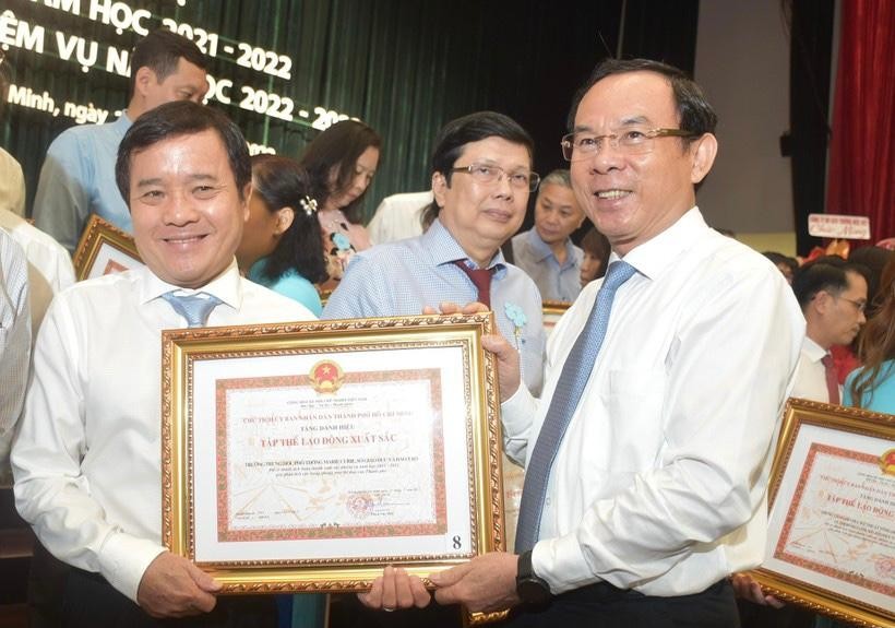 Bí thư Thành ủy TPHCM Nguyễn Văn Nên (bìa phải) trao bằng khen cho đại diện tập thể đạt danh hiệu tập thể lao động xuất sắc năm học 2021-2022.