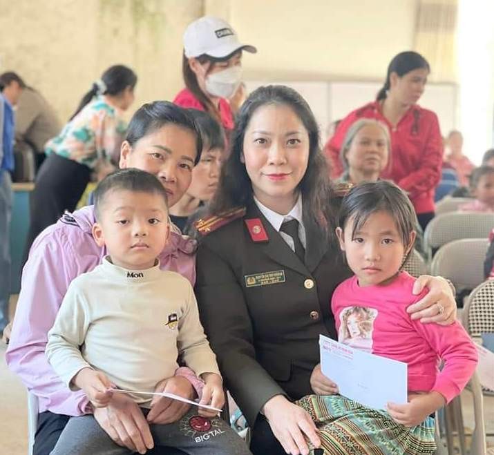 Trung tá Nguyễn Thị Thu Phương cùng các đồng nghiệp của Báo CAND tặng quà cho các em học sinh nghèo. Ảnh NVCC.