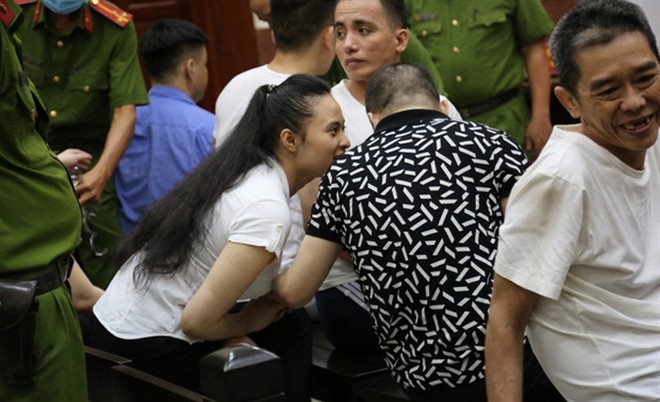 Bị cáo Văn Kính Dương và Ngọc Miu nắm tay trong thời gian tòa giải lao để nghị án. Ảnh: VTC News.