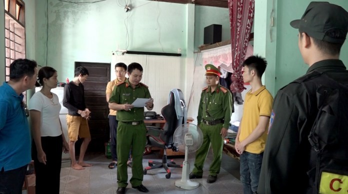 Lực lượng công an đọc lệnh giữ người trong trường hợp khẩn cấp đối với Võ Hữu Song (áo vàng thứ 2 từ phải sang)