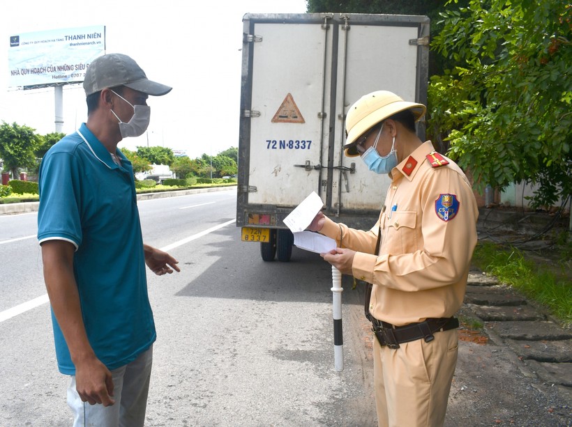 Lực lượng CSGT tại chốt kiểm tra y tế khu vực cầu Cỏ May (phường 12, TP. Vũng Tàu) kiểm tra giấy xét nghiệm âm tính COVID-19 một tài xế xe tải khi phương tiện qua chốt. Ảnh: Sa Huỳnh.